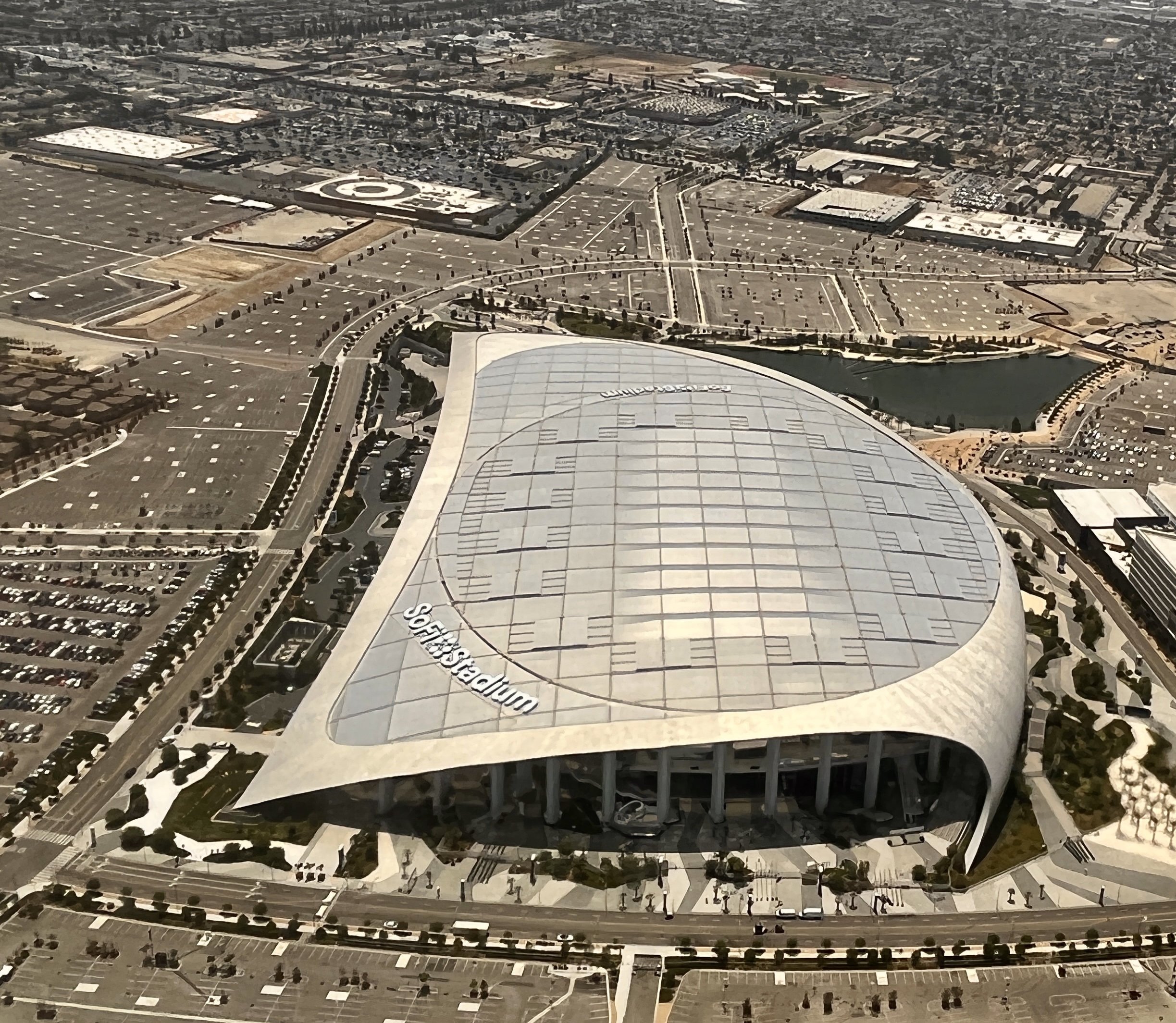 Aerial photograph of SoFi Stadium and its sweeping roof in Inglewood, Los Angeles